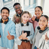 Gruppe lachender Personen mit erhobenem Daumen